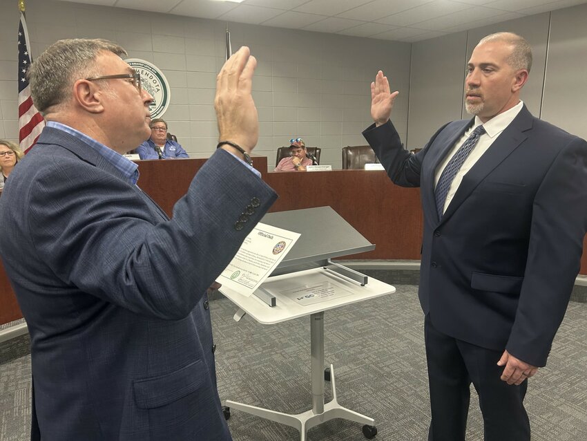 Jason Martin, right, is given the oath of office by his brother, Todd Martin to become the new Chief of Police of the Mendota Police Department at the April 21 city council meeting. (Reporter photo)