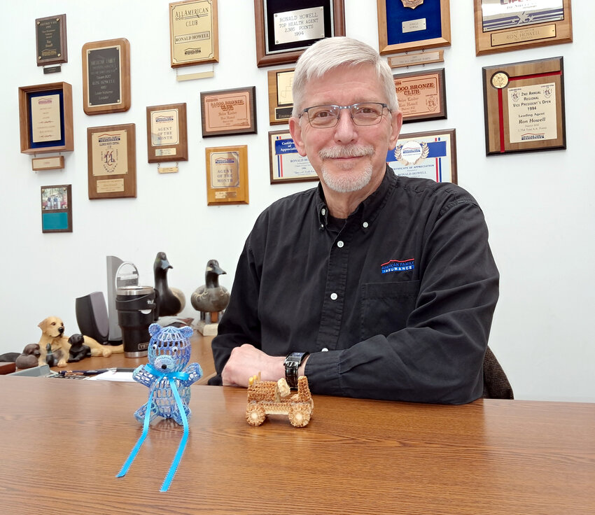 Clinton Amercian Family agent Ron Howell with two handmade items given to him over the years by his customers.