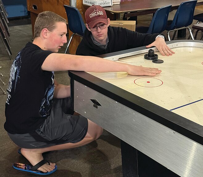 sophomores Aaron Costner, left, and Anthony Linder try to figure out what is wrong with the Teen Turf air hockey table.