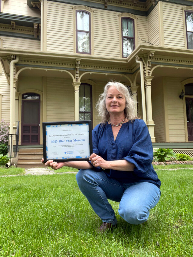 Museum director Joey Long with a certificate marking the museum as a Blue Star participant.