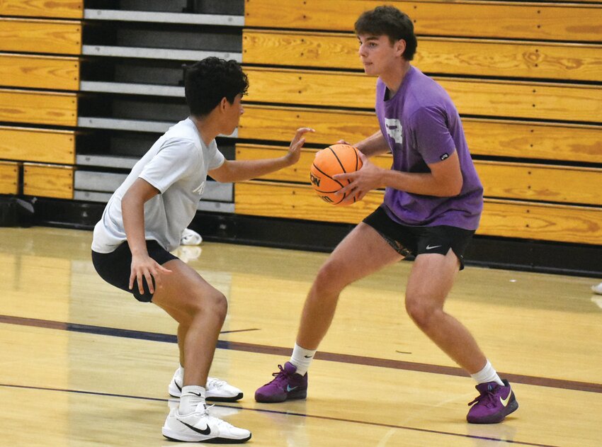 Sophomore Kasin Avila (left) guards senior Brode Metzger (right) during the Rochelle Hub basketball team's summer camp on Thursday.