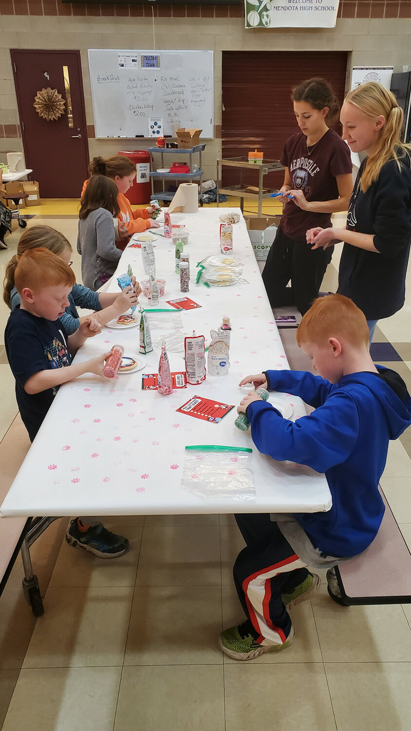 Mendota High School Interact Club members help children make neat Christmas stuff as part of a fundraiser for the school’s art department. (Reporter photo by Brandon LaChance)
