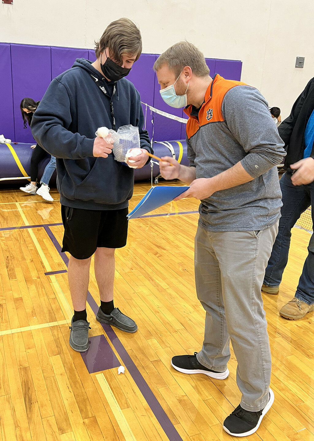 Mendota High School senior Jacob Swope, left, shows teacher Joe Hughes his surviving egg after withstanding a drop from 8 meters (about 26 feet) during an egg drop project in physics class. MHS students and staff, as well as visitors to MHS, will be required to continue to wear face masks while in the building.