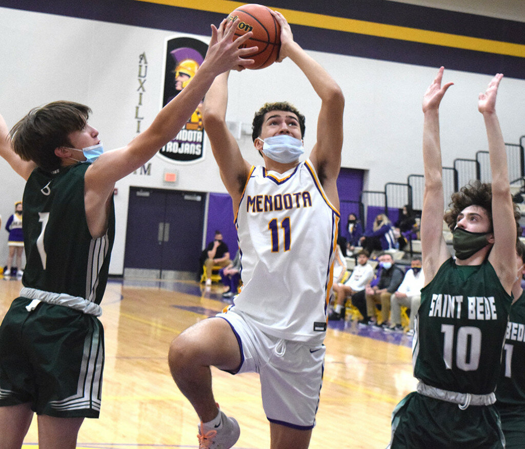 Mendota’s Rafael Romero eyes the basket as St. Bede’s Jake Bradach, left, and Duncan Lawler apply defensive pressure on Jan. 28 at the MHS gym. (Reporter photo)