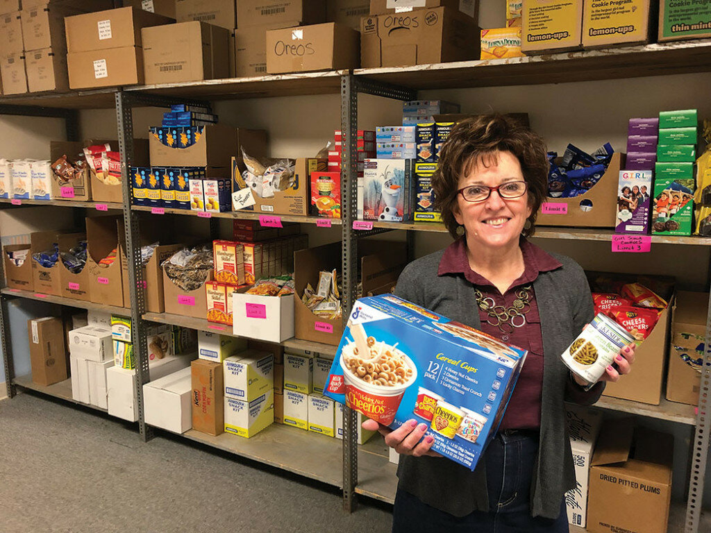 Carol Fritz poses in front of the shelves of the First Baptist Church Food Pantry.
George Howe/Amboy News
