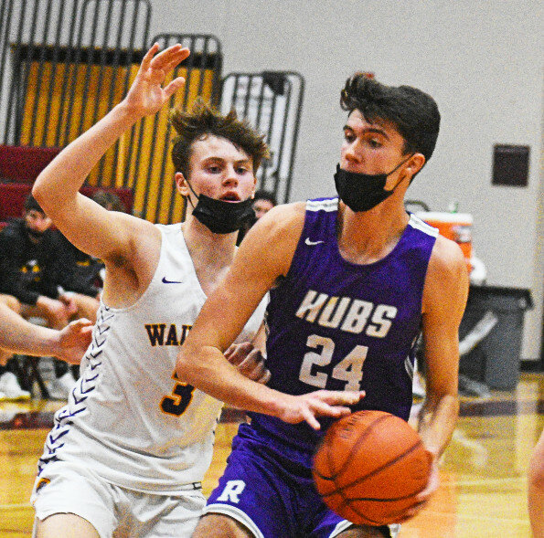 Senior Ryan Simmons avoids the outstretched hand of Wauconda’s Cayden Mudd during the Rochelle Hub varsity basketball game against the Bulldogs on Tuesday. Simmons scored a career-high 38 points. (Photo by Russell Hodges)