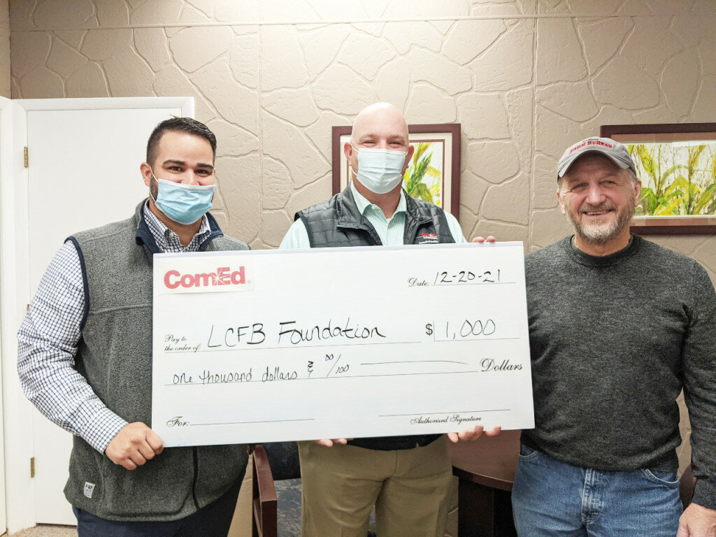 Nick Escobar, ComEd external affairs manager (left) and Thomas Przytulski, ComEd state and governmental affairs manager (center) present Larry Hummel, Lee County Farm Bureau Foundation president (right) with the contribution.