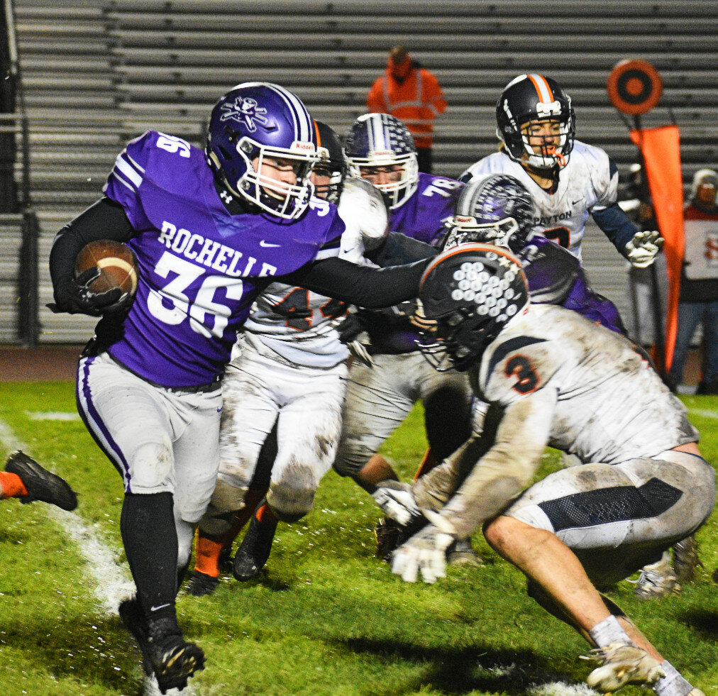 Junior Landon DeLille puts a stiff arm on Chicago (Payton) defender Charlie Newton during the Rochelle Hub varsity football game against the Grizzlies on Friday. (Photo by Russell Hodges)