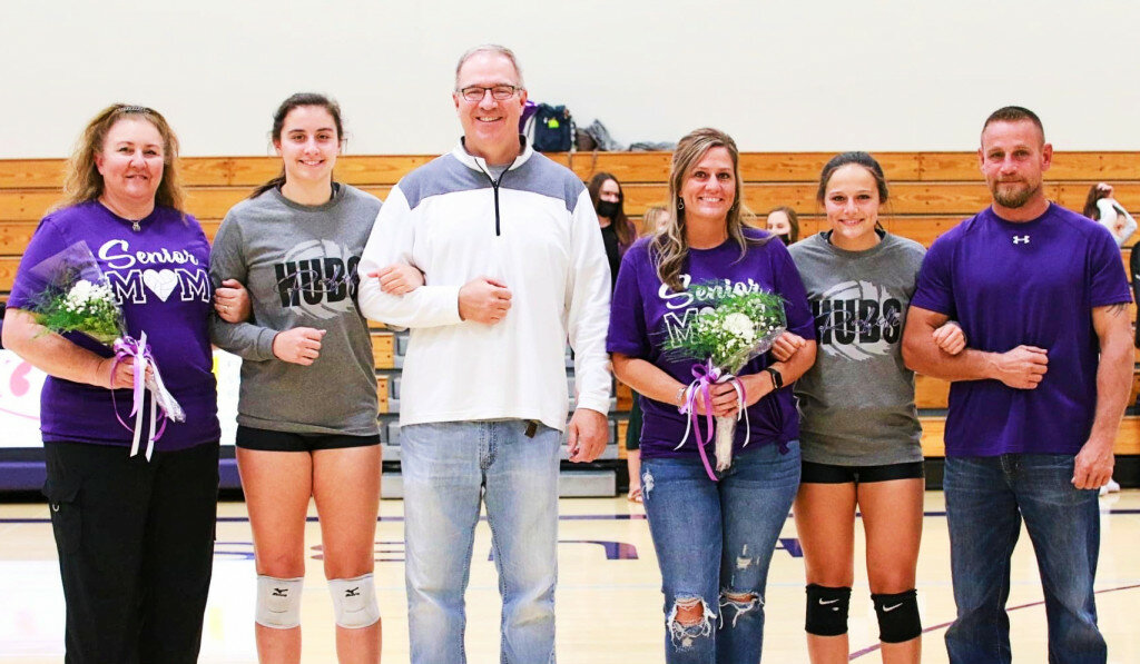 The Rochelle Lady Hub varsity volleyball team recognized seniors Sylvia Hasz (left) and Zoey Tabor (right) before scoring a home victory over the Plano Reapers on Monday. Hasz and Tabor are pictured above with their families during the pregame Senior Night ceremony. (Photo by Marcy DeLille)