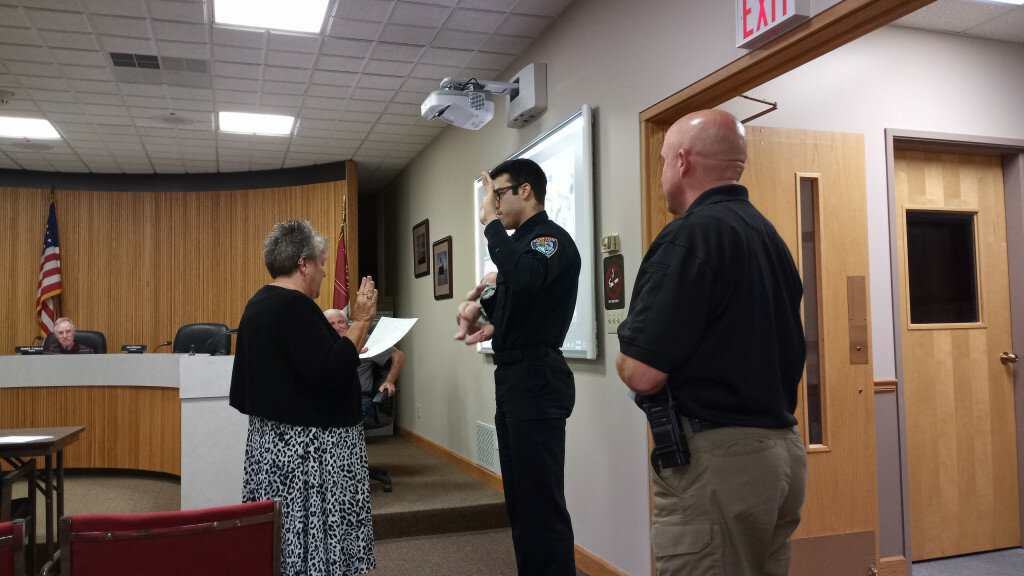 Gordon Woods / Journal — 
Clinton City Clerk Cheryl Van Valey administers the oath to Officer Joe Krasny for his promotion to a supervisory position with the Clinton Police Department.  With Kransy was his new son and his wife, not pictured.  Also, shown at right, Clinton Chief of Police Ben Lowers.