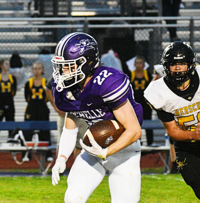 Junior Trey Taft carries the ball for the Rochelle Hub varsity football team during Friday's game against Herscher. (Photo by Russell Hodges)