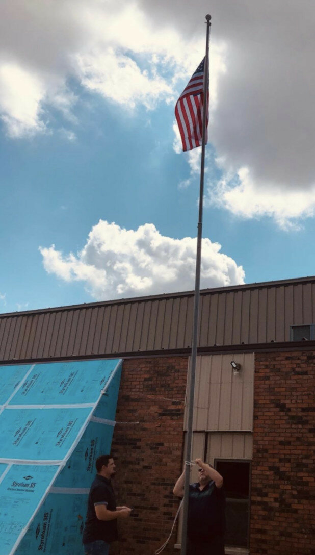 Courtesy of Clinton Assembly of God — A U.S. flag now flies at the Clinton Assembly of God church for the first time in more than a year.  A fire destroyed the sanctuary building in June 2020.  The church held a flag-raising ceremony in honor of late church member Ed Reynolds.  Reynolds, a U.S. Marine Corps veteran, ensured the flag always flew at the church and replaced it when necessary.  He was a teacher at the church academy until his health failed.  Pictured is Pastor Nick Blacklidge, left, and Dennis Reynolds.