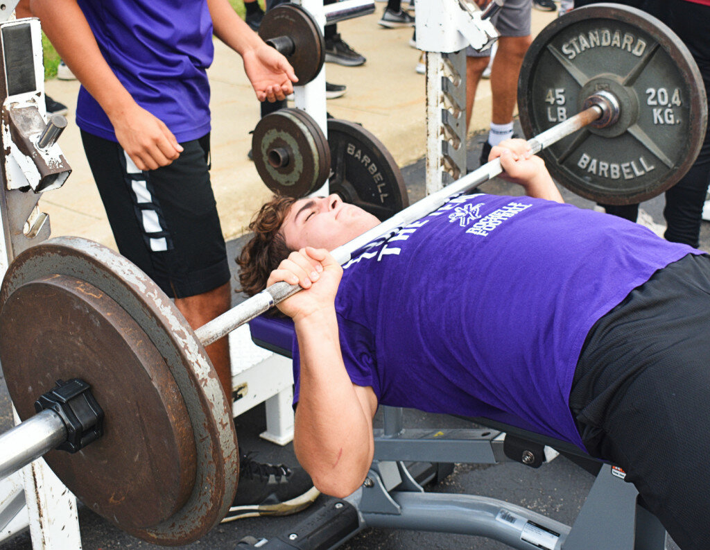 Junior lineman Jaden Cook performs the bench press during the Rochelle Township High School football program’s annual Lift-A-Thon event Tuesday evening. (Photo by Russell Hodges)