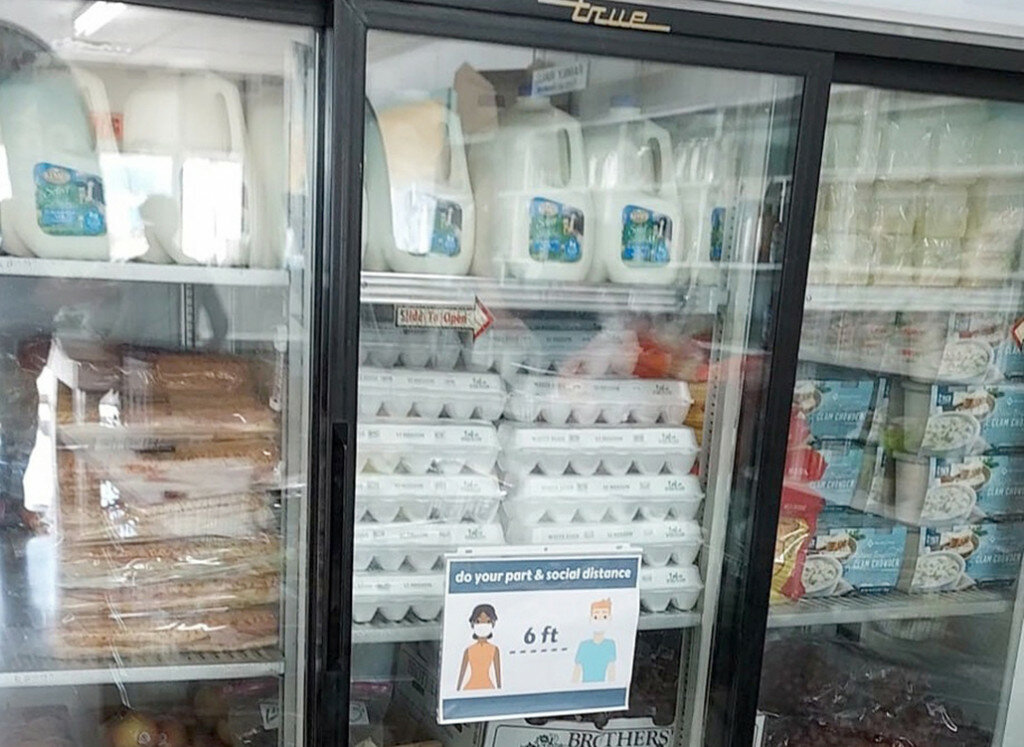 The food pantry cooler is stocked with milk, eggs and other items.