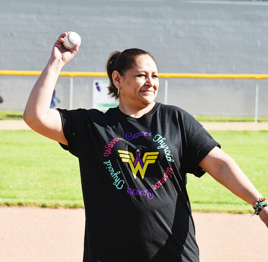 Lupe Ponce tosses the ceremonial first pitch at Floyd J. Tilton Park on Tuesday, when Rochelle Little League celebrated National Cancer Survivor Month. (Photo by Russell Hodges)