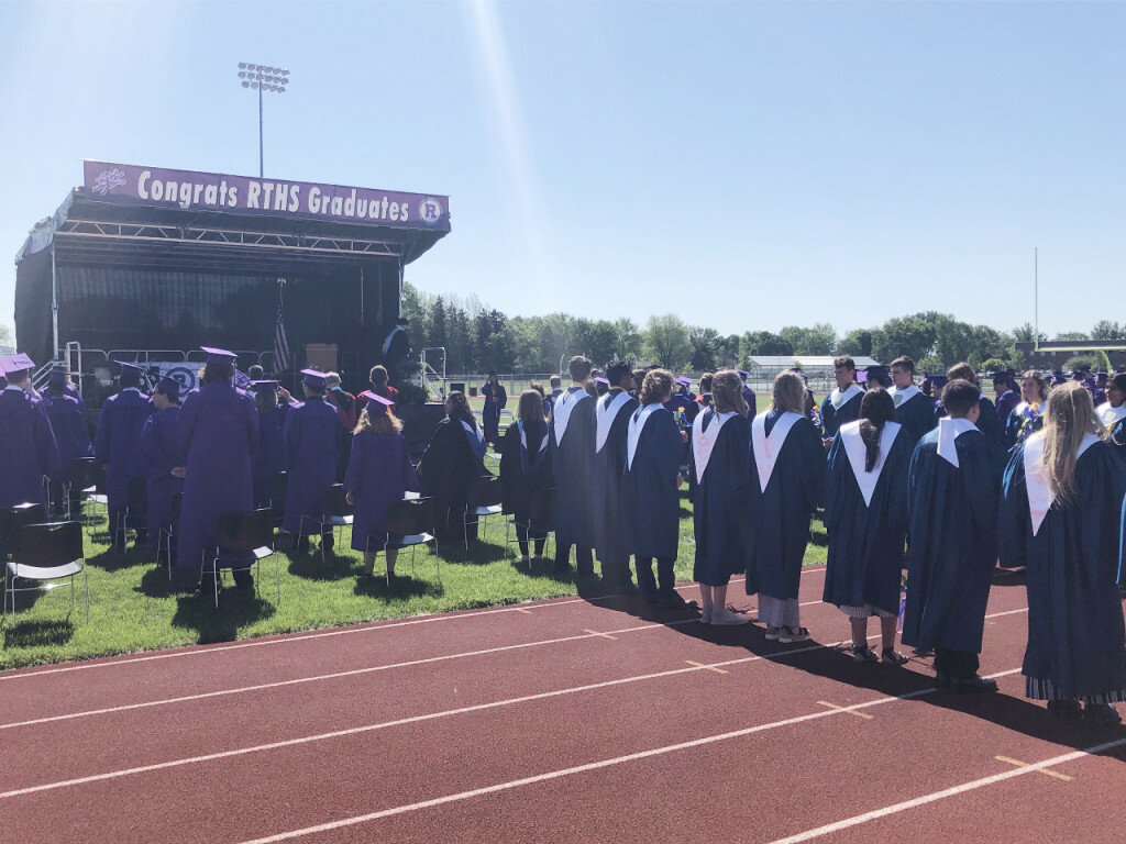 The ceremony was held outdoors on the football field to allow for more attendance. Students were allowed seven tickets each for their families. The stands were nearly filled. Students sat in chairs in front of a stage on the field.