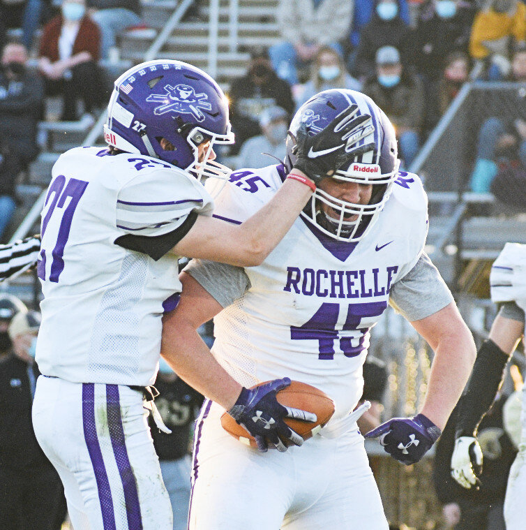 Rochelle senior Ethan Albers (right) celebrates an interception against Sycamore earlier this season. Albers committed to continuing his academics and his football career at Wartburg College next year. (Photo by Russell Hodges)