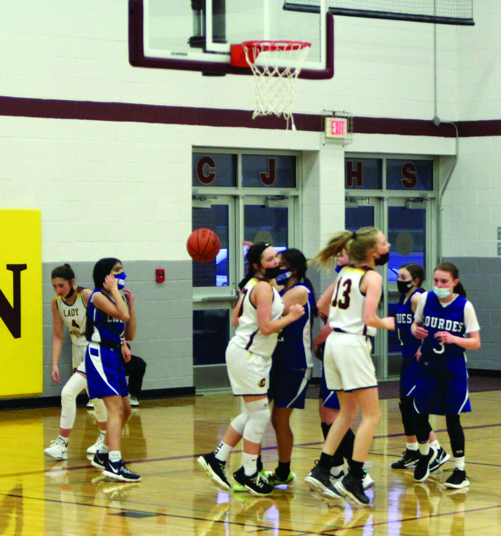 Reagan Filkin (#4) appears from under the basket after scoring a break-away lay-up.