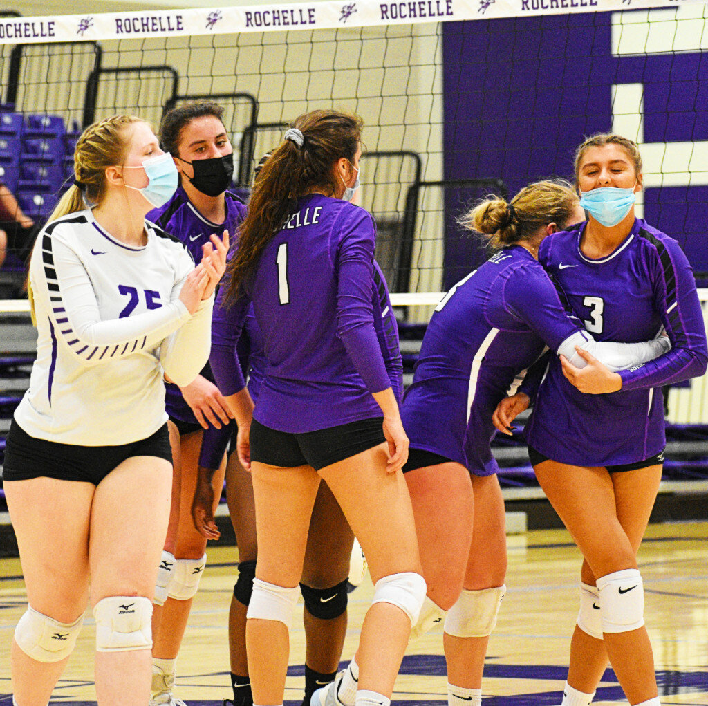 Members of the Rochelle Lady Hub varsity volleyball team celebrate with senior Bella Lodico (right) after a set-winning kill shot during a home match against Sycamore on Tuesday. (Photo by Russell Hodges)