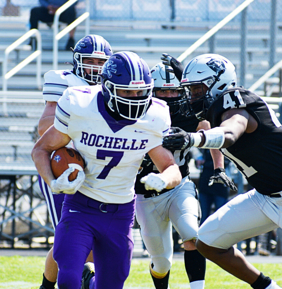 Senior Ben Harvey carries the football for the Rochelle Hub varsity team during Saturday's road game against Kaneland. Harvey rushed for a team-high 117 yards and one touchdown. (Photo by Russell Hodges)