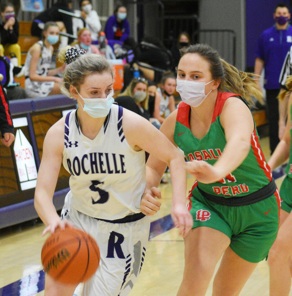 Junior Lucy Bunger battles with LaSalle-Peru's Jenisis Greening during the Rochelle Lady Hub varsity basketball game against the Cavaliers on Monday. (Photo by Russell Hodges)
