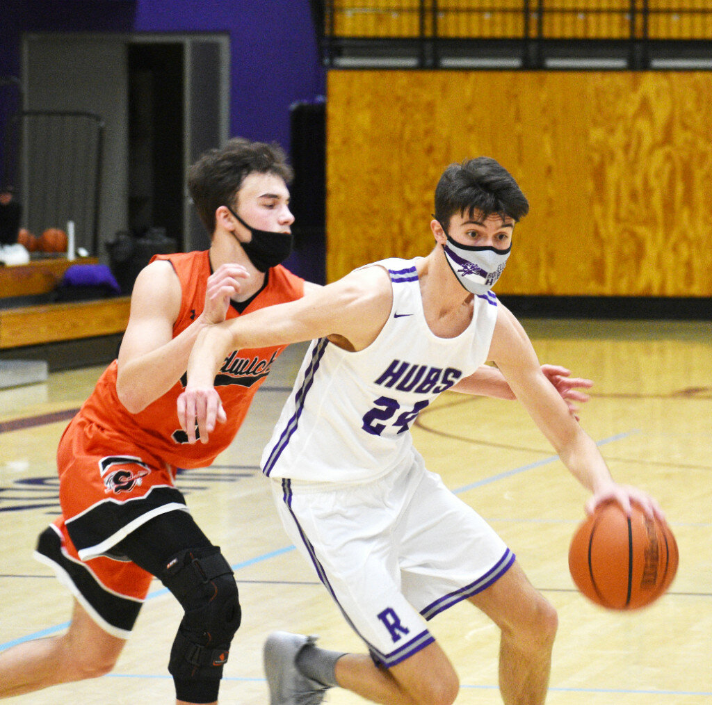 Junior Ryan Simmons drives away from Sandwich guard Cade Miller during the Rochelle Hub varsity basketball game against the Indians on Wednesday. Simmons scored 16 points and made four 3-pointers in the win. (Photo by Russell Hodges)