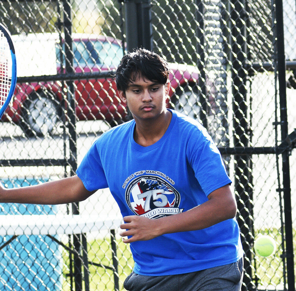 Junior Devansh Patel smashes a forehand shot during tennis practice this past week. Patel is one of a few Hub tennis players who have taken advantage of the 20 fall contact days allowed by the Illinois High School Association. (Photo by Russell Hodges)
