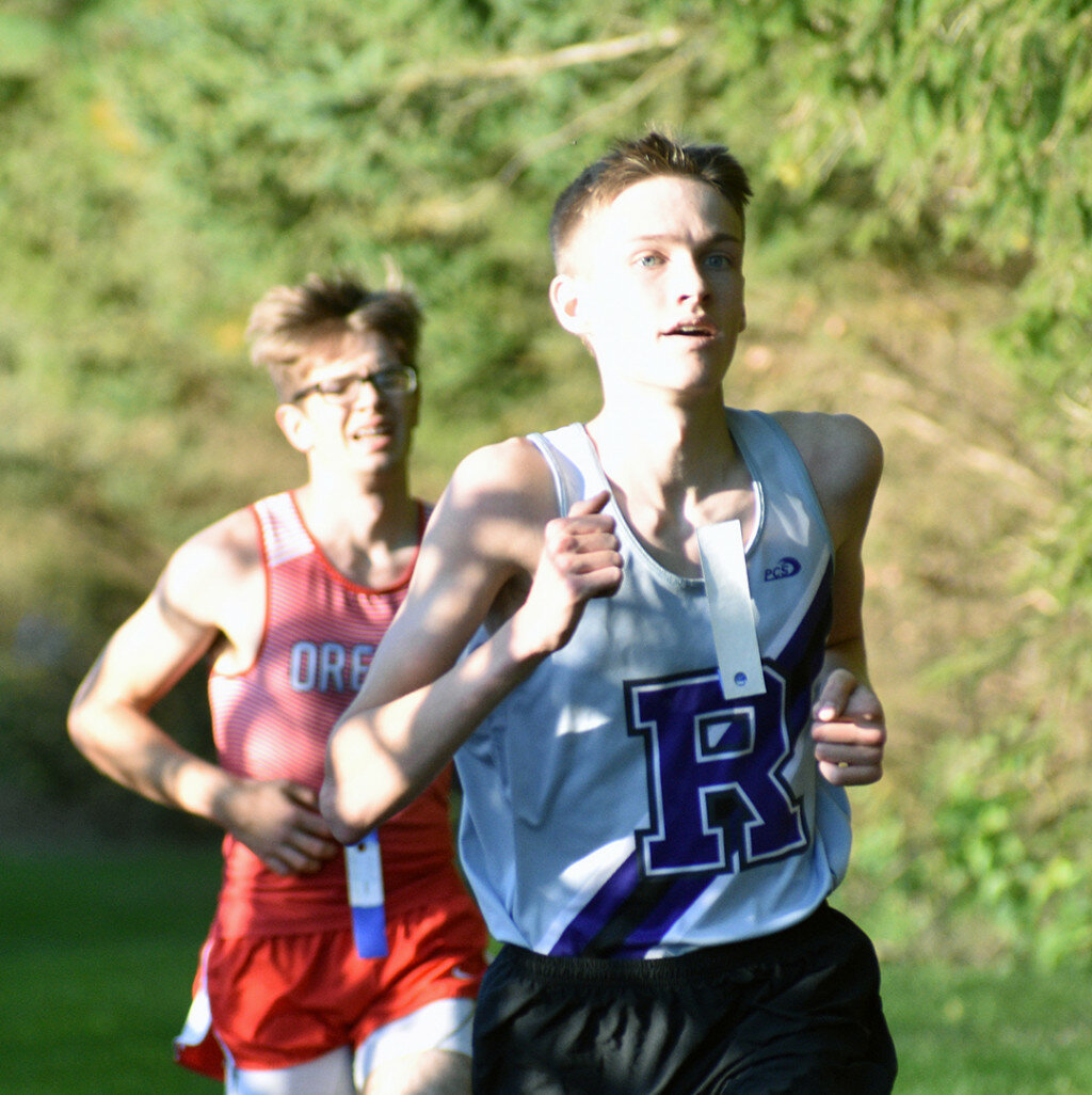 Senior Aiden Seldal outpaces Oregon's Ryan Hussung during the final stretch of the Rochelle cross country race against the Hawks on Thursday. (Photo by Russell Hodges)
