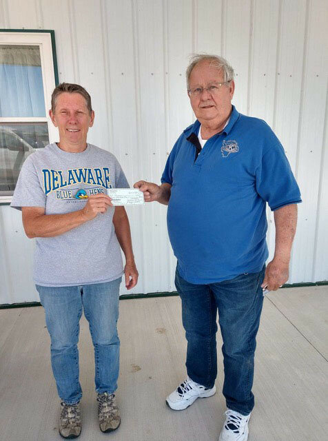 Above, Kiwanian Dennis Swinton, left, presents 
Pegasus Special Riders administrator Ellie Brauhn with a donation.