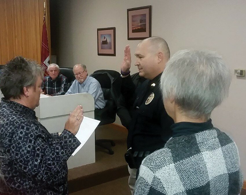 Gordon Woods / Journal — 
Clinton Police Department officer Tom Anderson takes the oath as newly-promoted sergeant from city clerk Cheryl Van Valey.   At right is Anderson’s mother; his wife, not pictured, also was present.