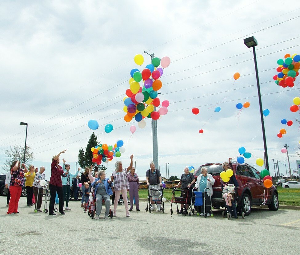 Gordon Woods / Journal
Residents of Hawthorne Inn gather in the facility’s parking lot on a windy Monday to mark National Supportive Living Week.  Hawthorne Inn also will host a car show on Friday to mark the event.