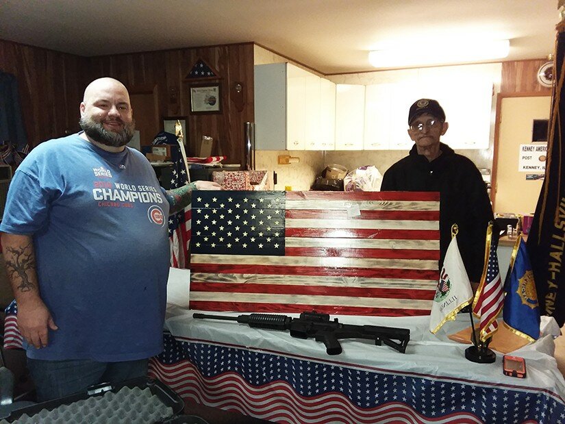 Gordon Woods / Journal
Doug Scott, left, picked up his AR15 carbine and American flag-style gun case recently as the winner of the Kenney-Hallsville American Legion gun raffle. With Scott is Legion commander Harold Parsons.  The Legion Post sold more than 250 tickets in this year’s raffle.