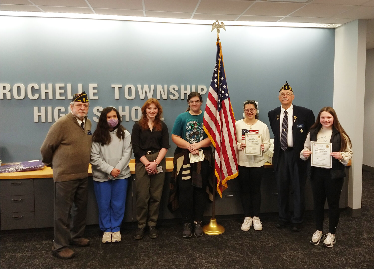 Rochelle Township High School winners from left to right: John Gruben (commander, American Legion Post 403), Brizuela Xitlali (honorable mention), Kyra Bivins (honorable mention), Kathryn Groves (second place, Class II), Jessica Nguyen (first place, Class 1), Steve Korth (adjutant, American Legion Post 403) and Magdalene Good (first place, Class II). Not shown: Aiden Ramsey, second place, Class I.