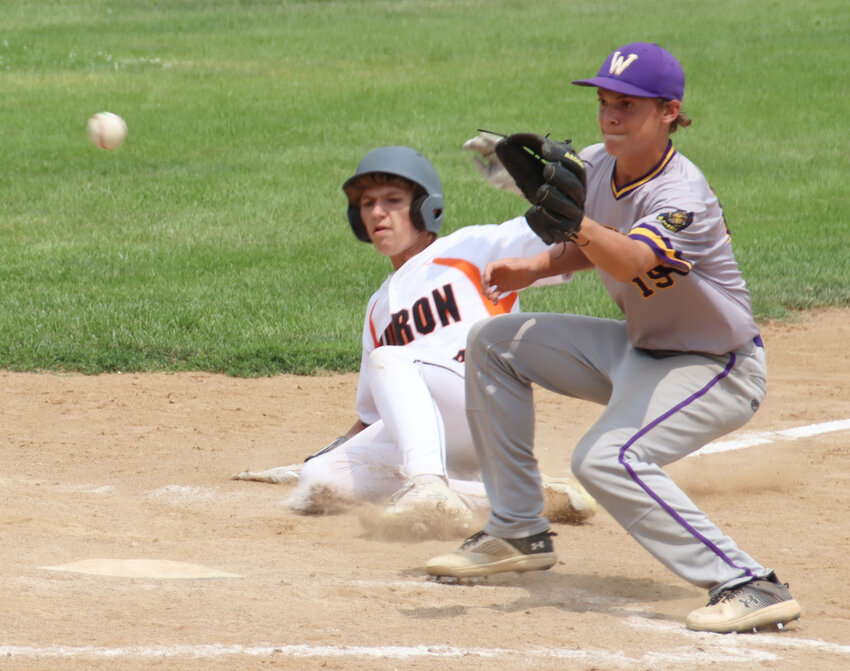 Huron’s Zach Scheer slides into home on a wild pitch as Watertown’s Caden Corey attempts to cover the plate during Sunday’s doubleheader at Memorial Field.