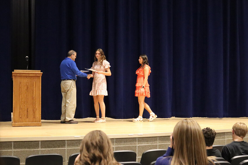 Paul Hodges awards Kaitlyn Rozell and Chloe Zens with Lions Club scholarships.