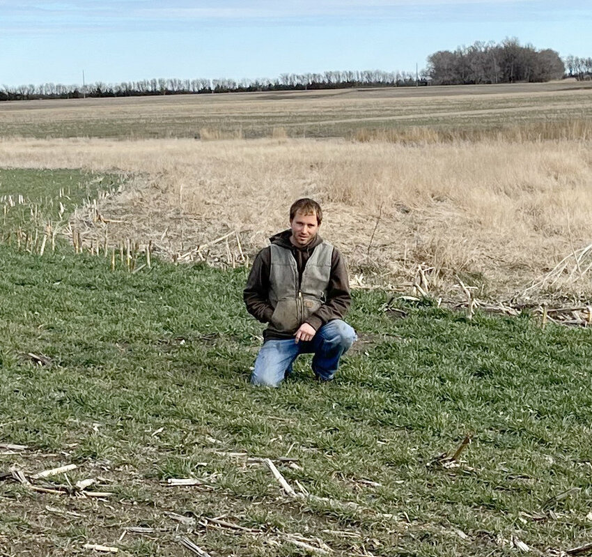 Luke Hiebert in a field of rye on his Huron farm. After he harvests this cereal grain late summer he will plant cover crops for his livestock to graze late fall. Cover crops are just one of several sustainable practices he implements to increase access to forage for his cow/calf herd.