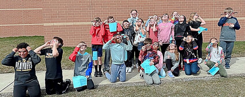 Kimberly Ristesund’s class uses eclipse glasses to observe the sun on April 5 outside of Camelot Intermediate School.