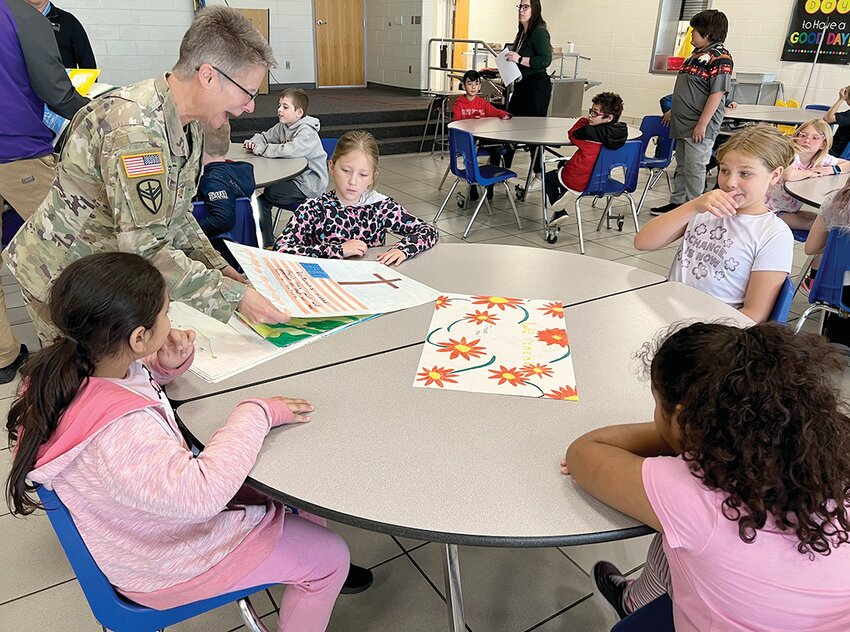 Local VFW Post Commander Maj. Bridget Flannery collects finished artwork from the FPS 3rd graders.