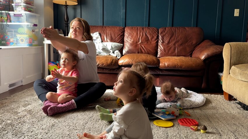 Karen Rieck and some of the children at her daycare follow a yoga video to wind down before parents arrive for pick-up.