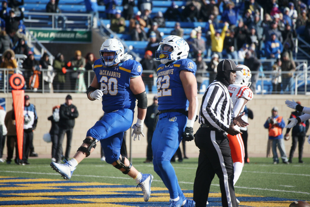 Jackrabbits offensive lineman Mason McCormick (60) celebrates after Isaiah Davis (22) scores a touchdown in the second quarter of an FCS second-round playoff game against Mercer at Dana J. Dykhouse Stadium in Brookings on Saturday afternoon. (Chris Schad/Brookings Register)