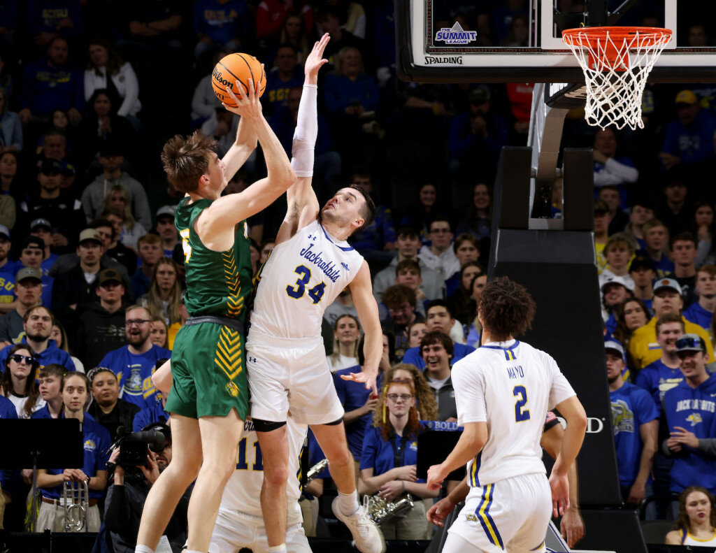Alex Arians #34 of the South Dakota State Jackrabbits leaps to block shot by Grant Nelson #4 of the North Dakota State Bison at the 2023 Summit League Basketball Championship at the Denny Sanford Premier Center in Sioux Falls, South Dakota. Nelson had 20 points and 22 rebounds in NDSU's 89-79 victory over SDSU. (Dave Eggen/Inertia)