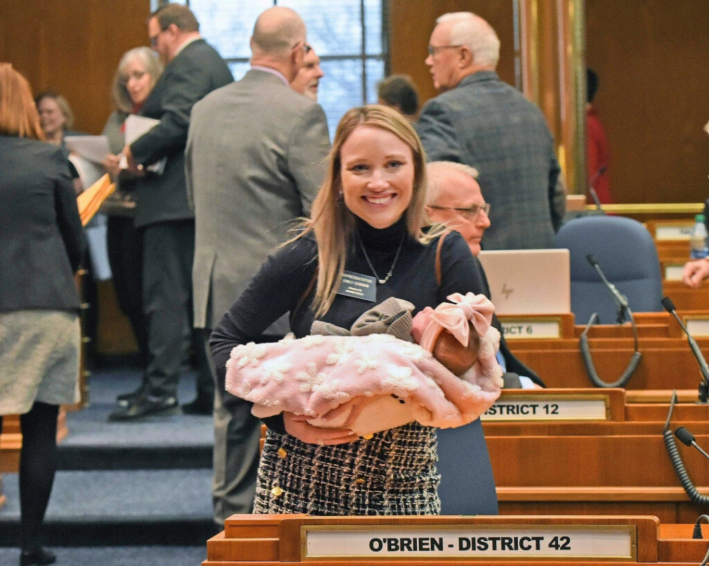 North Dakota state Rep. Emily O'Brien, R-Grand Forks, carries daughter Jolene Green, 3 weeks, into the House chamber on Dec. 6, 2022, in Bismarck, N.D. (Tom Stromme/The Bismarck Tribune via AP)