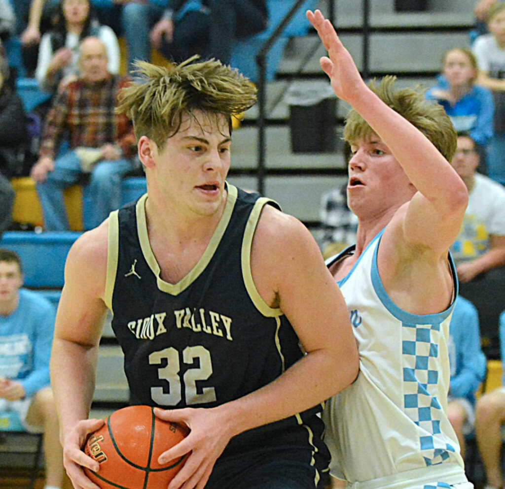 Sioux Valley’s Hudsyn Ruesink works in the lane against Hamlin’s Tyson Stevenson during a game in Hamlin on Monday. (Roger Merriam/Watertown Public Opinion)
