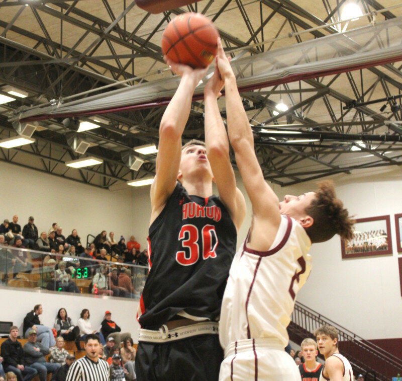 Huron’s Blake Ellwein goes up for a shot over the outstretched arms of Spearfish’s Kamren Davis in a game Friday night in Spearfish. The Tigers defeated the Spartans 59-50. 
Photo courtesy Dennis Knuckles Black Hills Pioneer