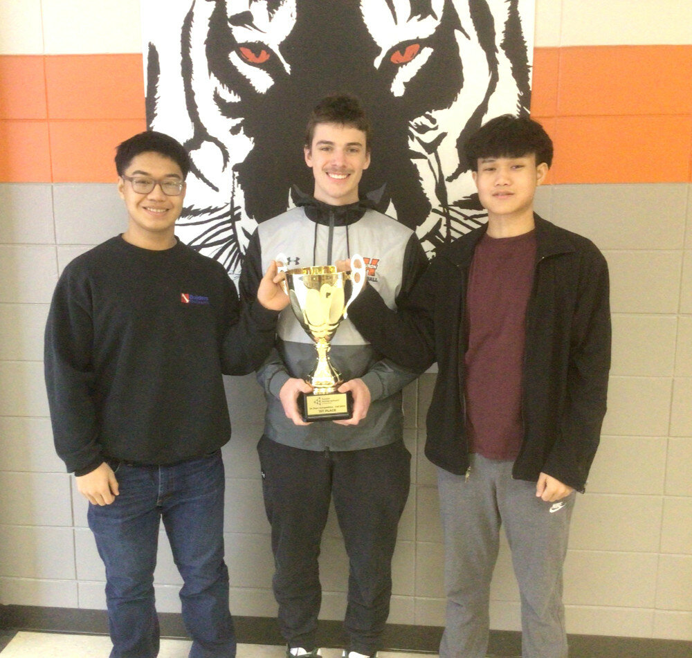 Courtesy photo
Huron High School Consumer Economics students Lah Ker Paw Htoo, Leeam Davis and Ehmu Dah pose with the trophy they were presented after winning the South Dakota Junior Achievement Titan Competition simulation game in December.