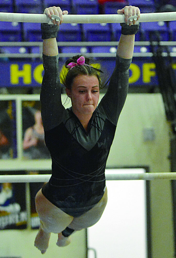 ROGER MERRIAM/WATERTOWN PUBLIC OPINION
Huron’s Eastyn Eichstadt competes on the bars during a triangular on Thursday in Watertown.