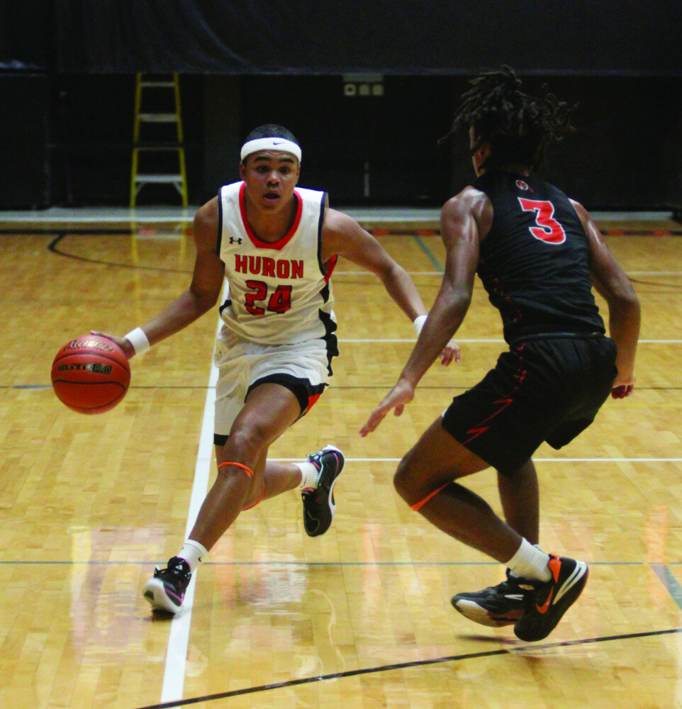 PHOTOS BY MIKE CARROLL/PLAINSMAN
Huron’s CJ Gainey dribbles on the perimeter against defensive pressure by Samuel Baskin of Sioux Falls Washington during their game Thursday at Huron Arena.