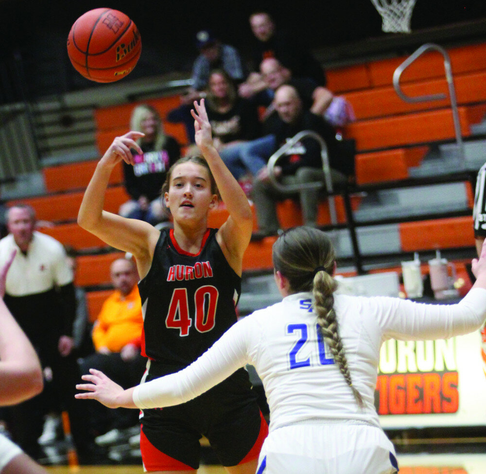 PHOTOS BY MIKE CARROLL/PLAINSMAN
Huron’s Tatum Peterson passes the ball as she is guarded by Isabell Higgins of Rapid City Stevens during their game Saturday at Huron Arena.