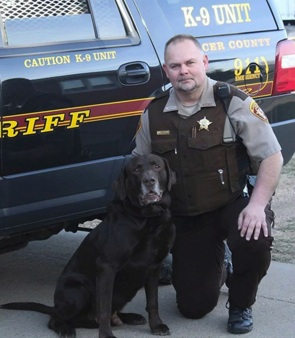 This undated photo provided by the Mercer County (N.D.) Sheriff's Office shows Sheriff's Deputy Paul Martin with his retired K9 Goliath, who died in 2019. Martin, 53, died Wednesday in a crash involving Ian Cramer, the 42-year-old son of Republican U.S. Sen. Kevin Cramer of North Dakota. (Mercer County Sheriff’s Office via AP)