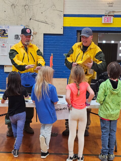 Second graders learn about firefighting from John Benton and Will deRyk, firefighters with Palmer Canyon Fire Department.